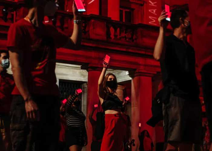 People standing and holding their phones up and pointed in front